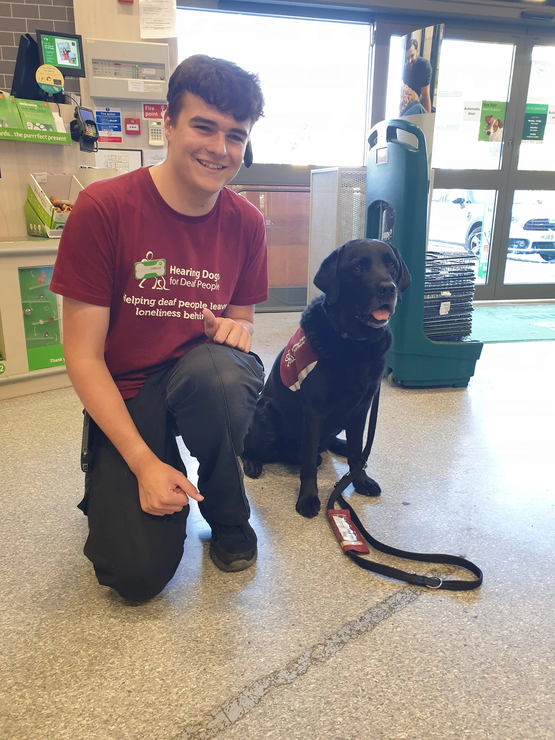 Colleague Odhran with black labrador Elmo in Poole store