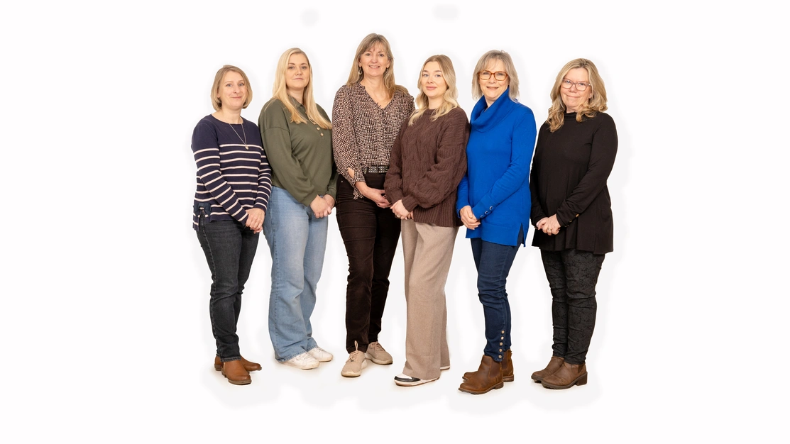 Group of six women standing against a white background