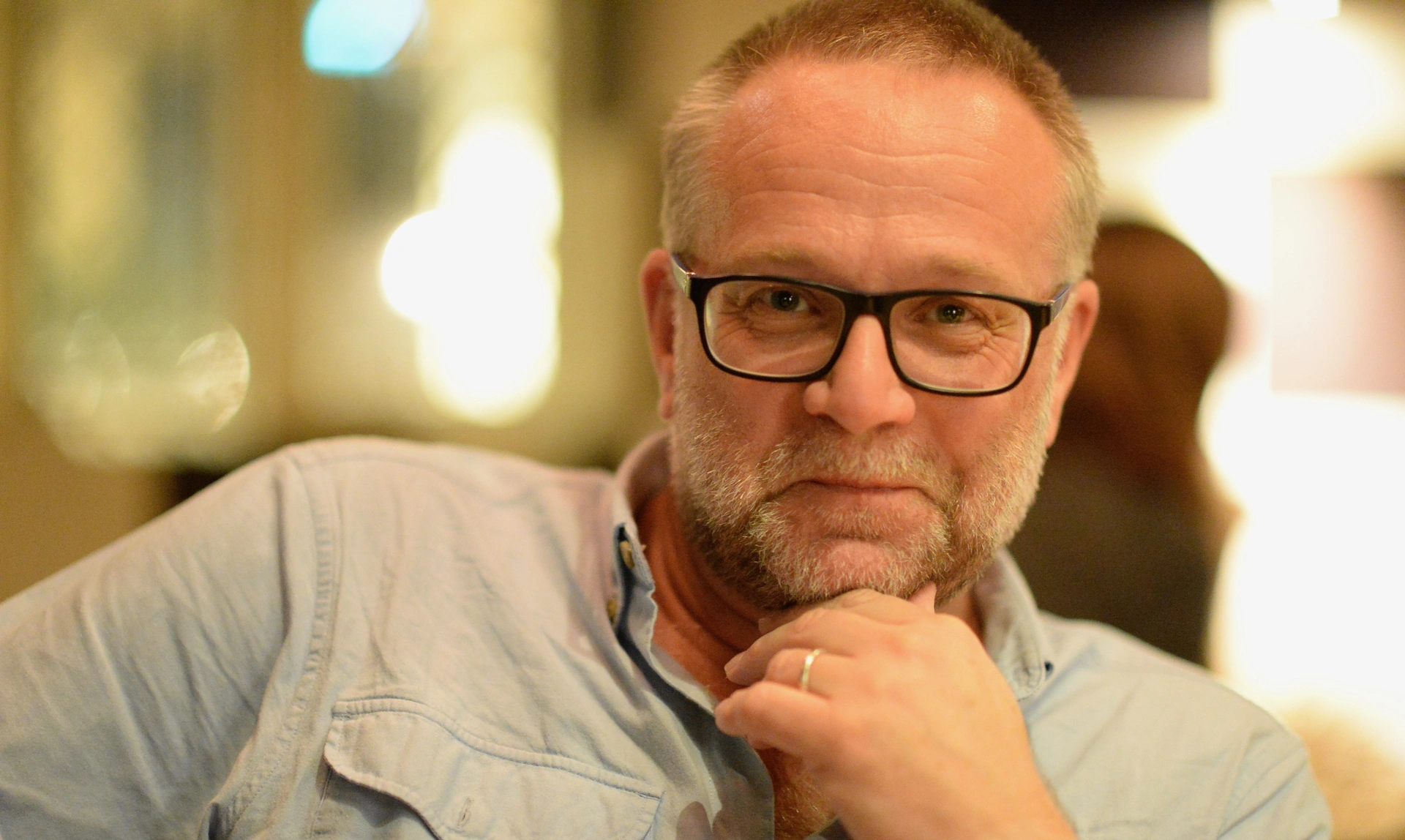 A man resting his hand on his chin looking at the camera