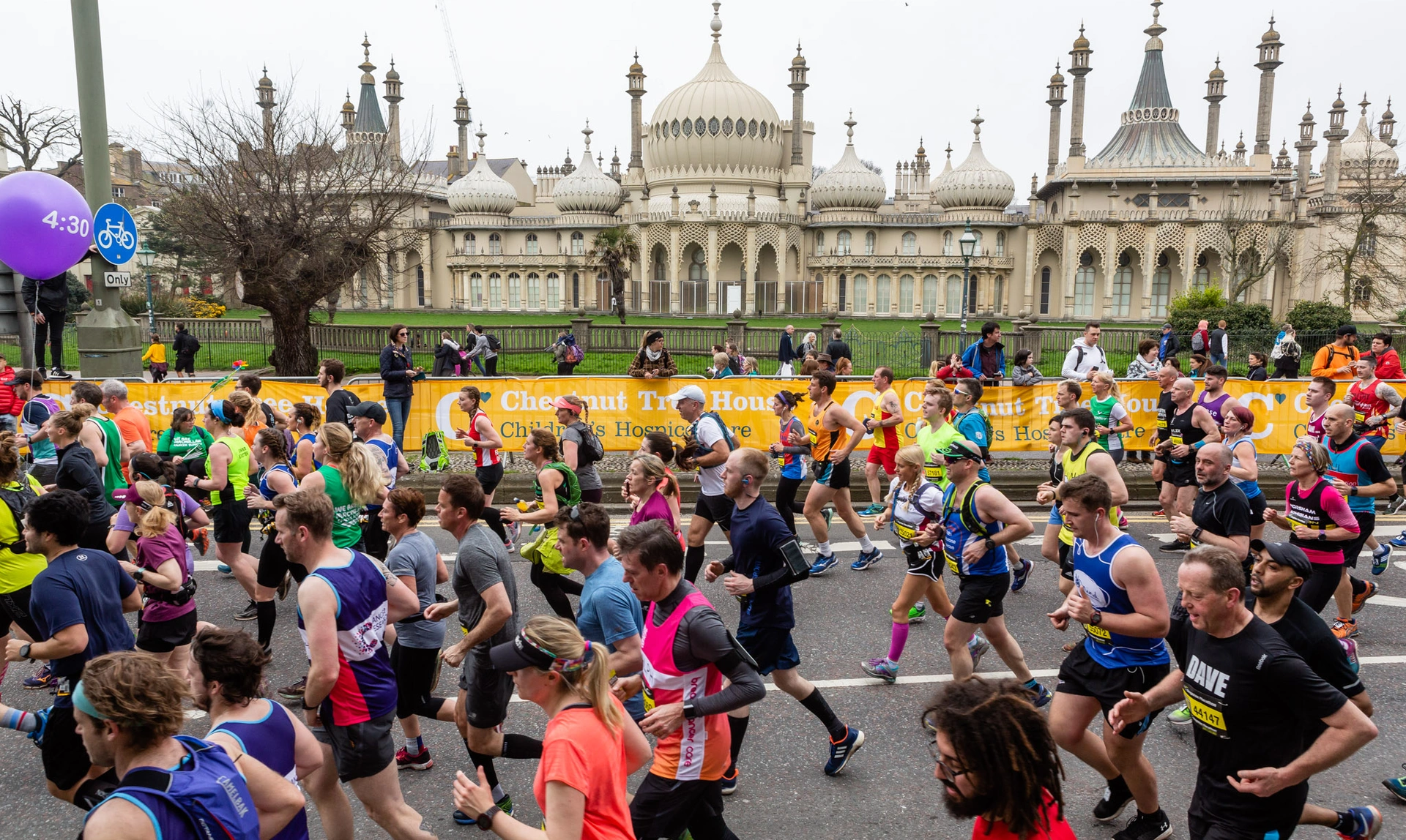 A large group of runners are pictured running with the Brighton Royal Pavilion seen in the background