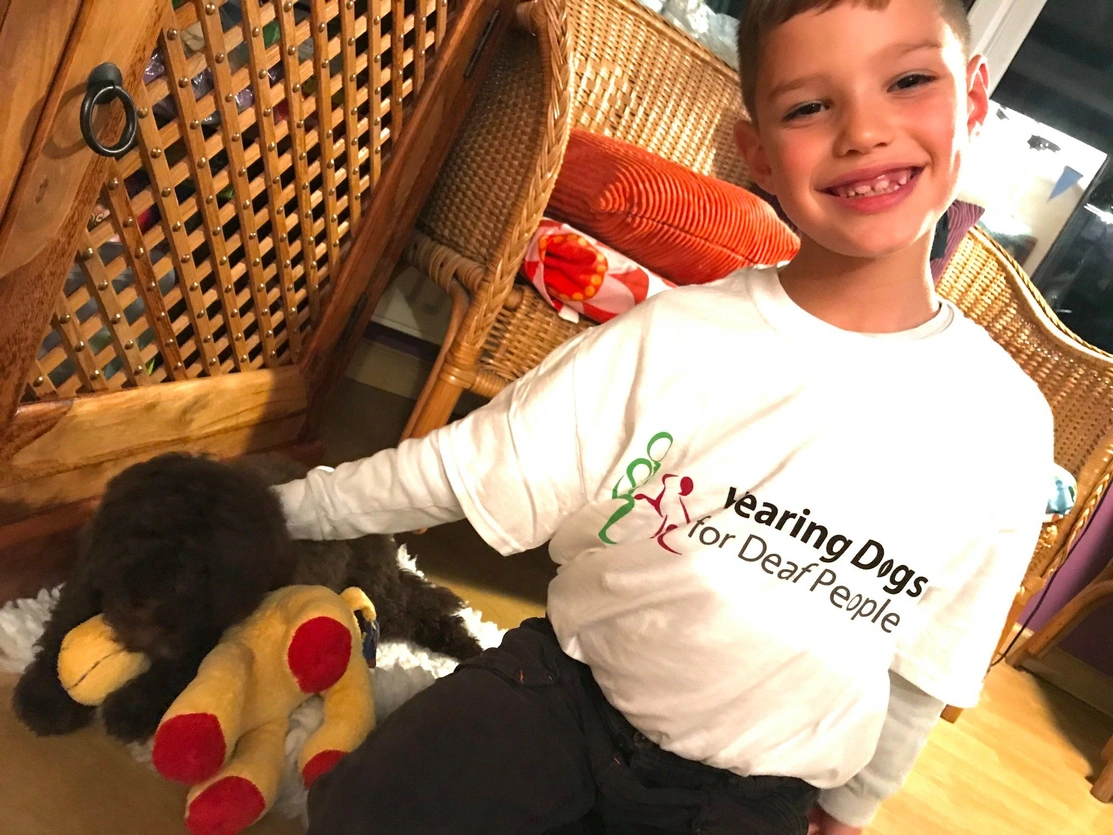 Child simling at the camera with a puppy