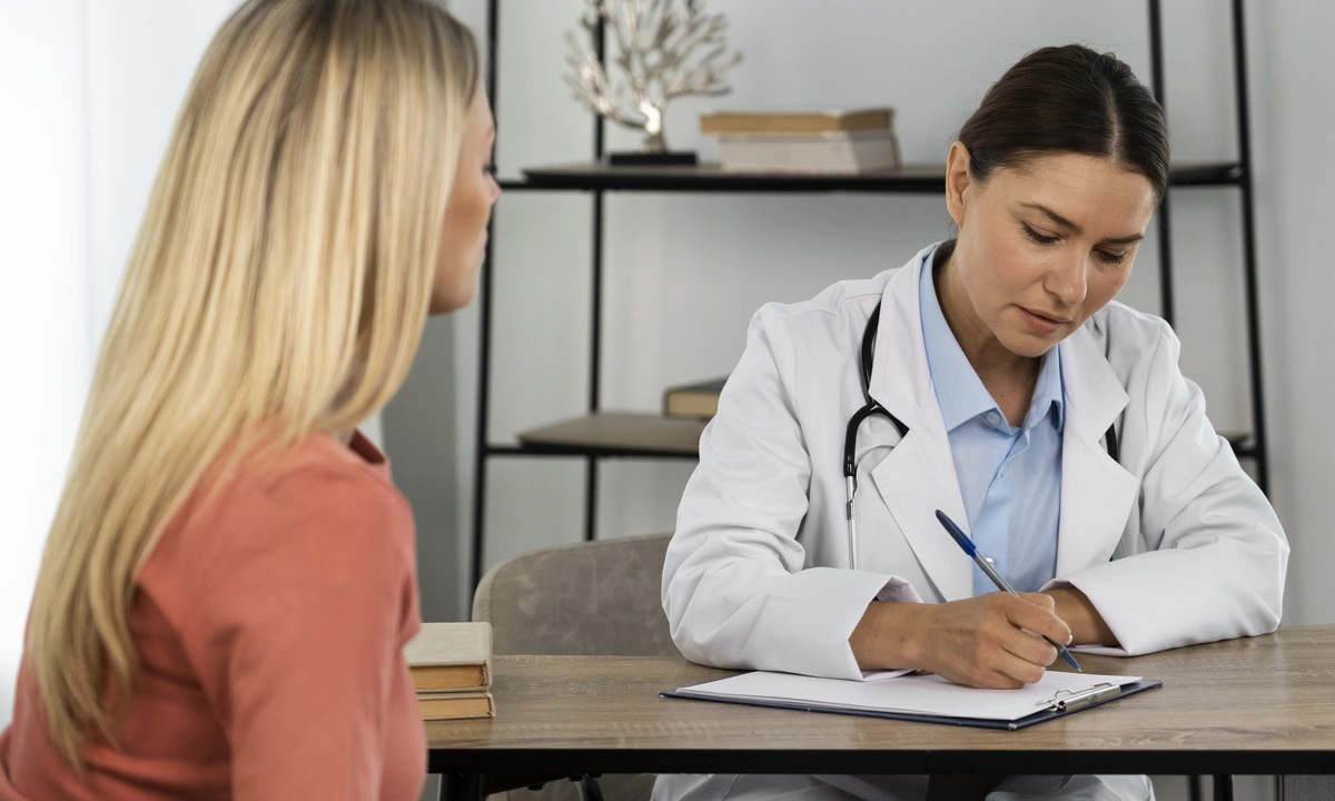 Side view of a young woman talking to a doctor