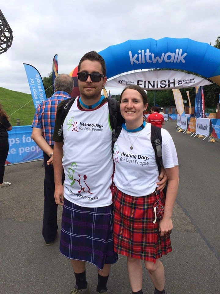 a man and a woman standing infront of the finish line for Kiltwalk