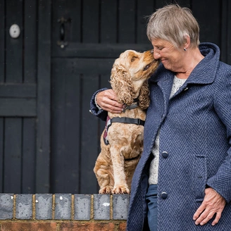 Woman cuddling golden cocker spaniel